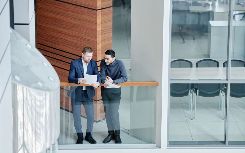 Two professionals reviewing documents in a modern office