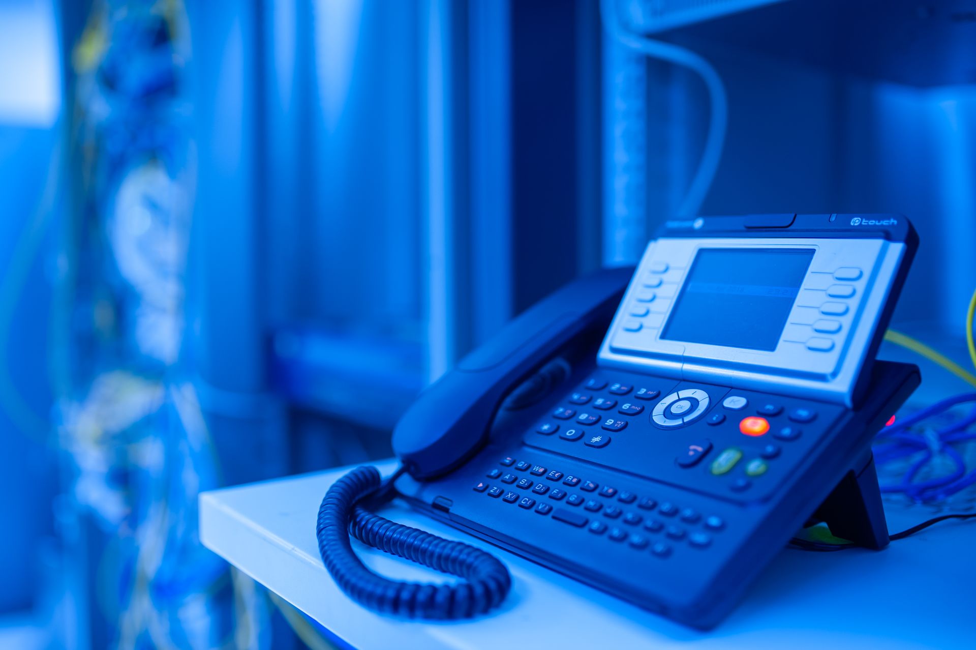 Modern IP phone handset with data center infrastructure in the background